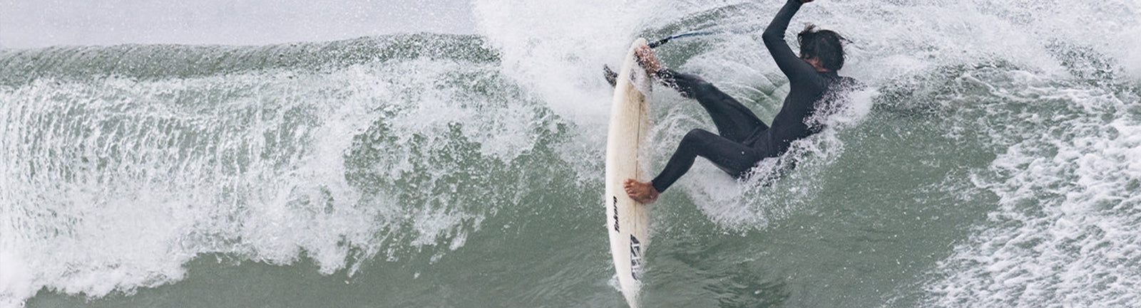 Image of a Surfer Slashing off the top in a wetsuit in cold water conditions